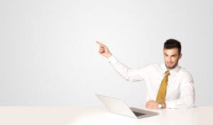Business man sitting at white table with a white laptop on white background