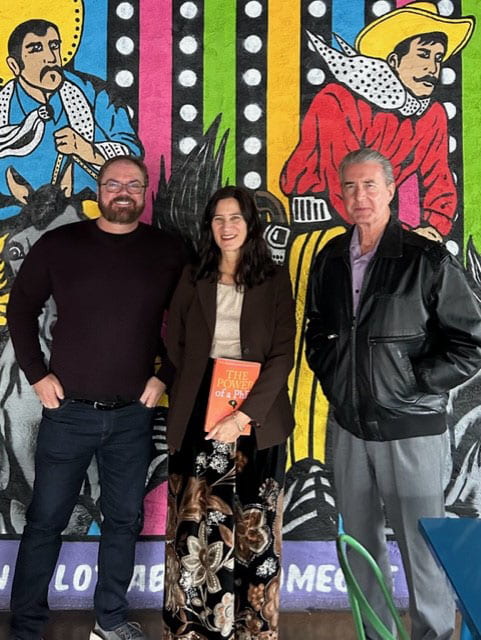 Drs. Dean Colston, Annette Padilla, and Ray Hopkins standing against a colorful, festive background at Ajo Al's Mexican Cafe.